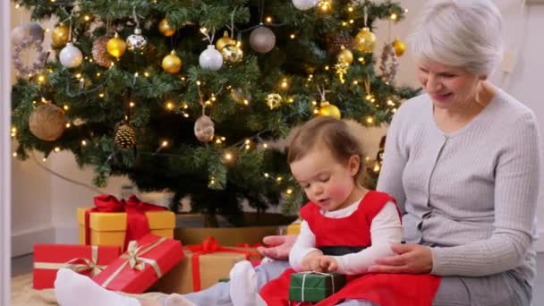 Nagymama és kislány karácsonyi ajándékokkal — Stock videók