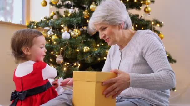 Grootmoeder en baby meisje opening kerstcadeau — Stockvideo