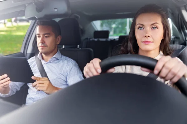 woman and driving school instructor in car