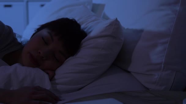 Sleeping woman awaking because of phone at night — Stock Video