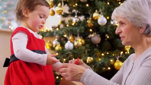 Nagymama és kislány nyitó karácsonyi ajándék — Stock videók