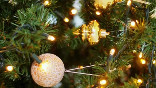 Goldener Weihnachtskugelschmuck auf Tanne — Stockvideo