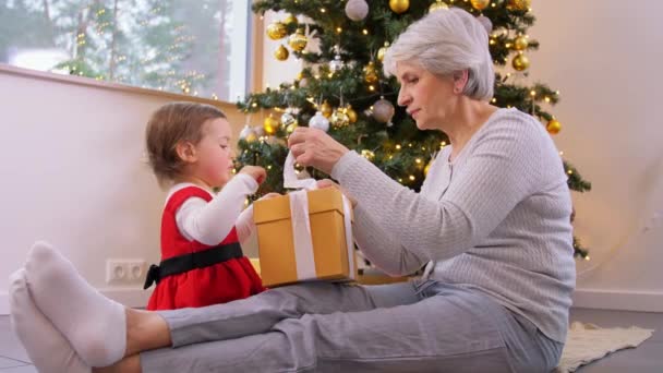 Avó e bebê menina abrindo presente de Natal — Vídeo de Stock