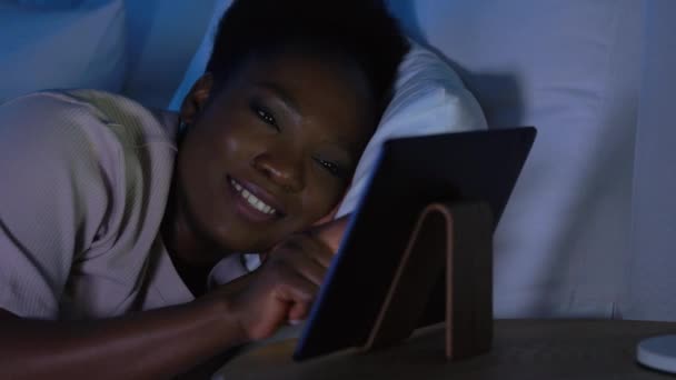 Vrouw met tablet pc in bed thuis 's nachts — Stockvideo