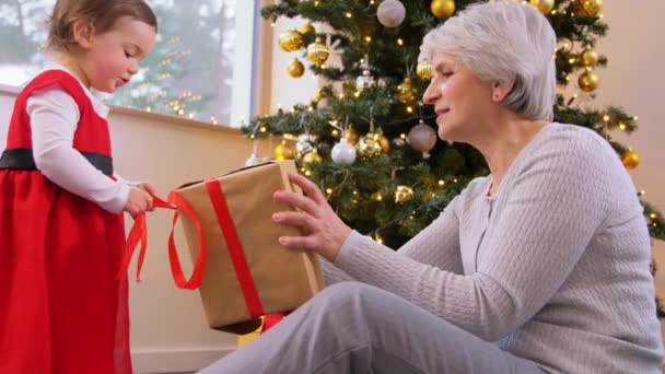 Büyükanne ve bebek yılbaşı hediyelerini açıyor. — Stok video