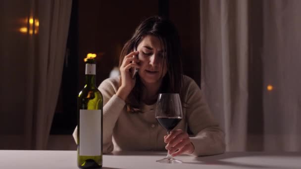 Алкоголичка пьет вино и звонит по телефону — стоковое видео