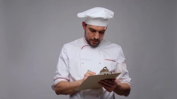 Mannelijke chef-kok met klembord en pen schrijven — Stockvideo