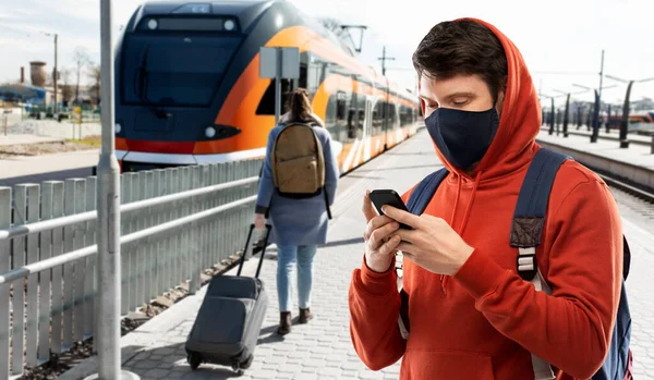 Homem em máscara com smartphone viajando de trem Imagem De Stock