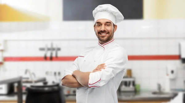 Gelukkig glimlachende mannelijke chef-kok in restaurant keuken Stockfoto