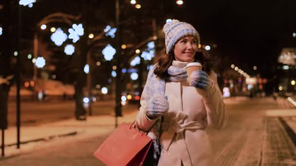 Kışın kahve ve alışveriş torbasıyla mutlu bir kadın. — Stok video