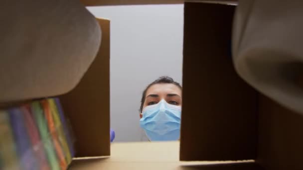 Kvinna i mask tar rengöringsmedel från lådan — Stockvideo