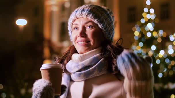 Szczęśliwa kobieta pijąca kawę przy lampkach świątecznych — Wideo stockowe