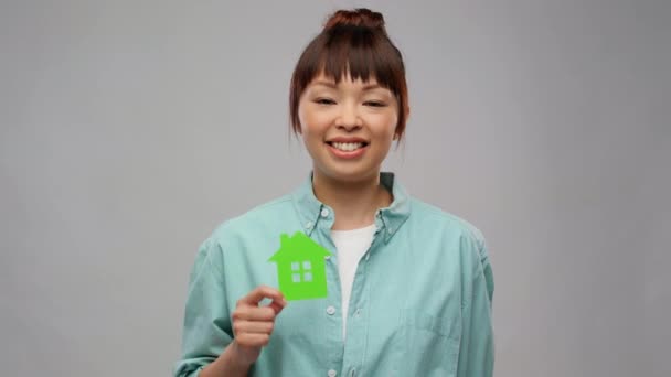 Азіатська жінка з зеленим будинком показує великі пальці вгору — стокове відео