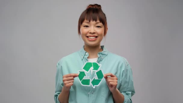 Glimlachende aziatische vrouw met groene recycling teken — Stockvideo