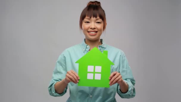 Mosolygós ázsiai nő gazdaság zöld ház — Stock videók