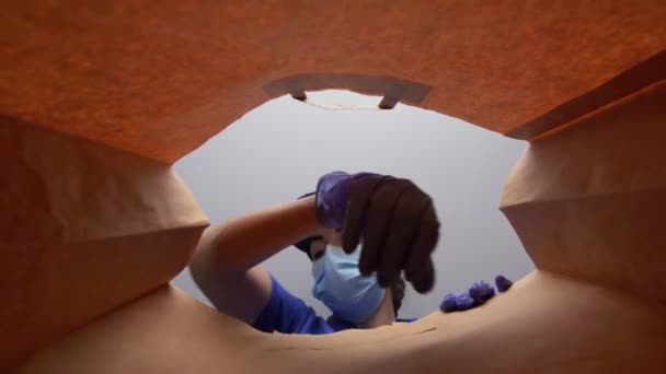 手袋をした女性と紙の袋に食品を詰めるマスク — ストック動画