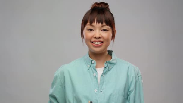 Gülümseyen Asyalı kadın ahşap diş fırçasıyla — Stok video