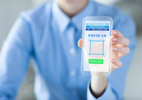 Рука з віртуальним паспортом імунітету на смартфоні — стокове фото