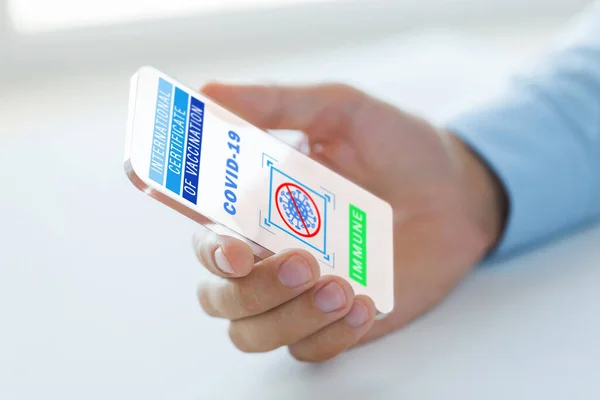 Mano con certificato di vaccinazione su smartphone — Foto Stock