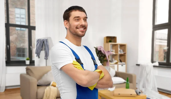 Gelukkig mannelijk werknemer of schoner in handschoenen thuis — Stockfoto