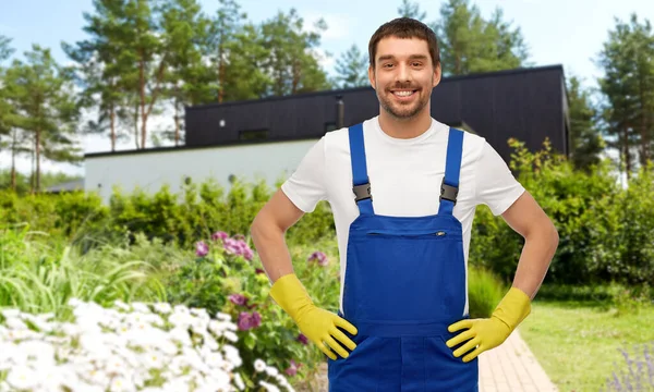 Glad manlig arbetare eller renare i handskar på trädgården — Stockfoto