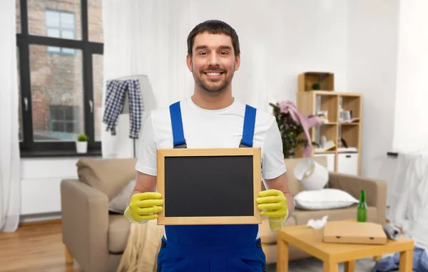Mužský pracovník nebo uklízeč s tabulí doma — Stock fotografie