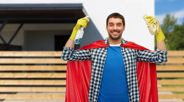 Uomo sorridente in mantello supereroe con straccio e pulitore — Foto Stock