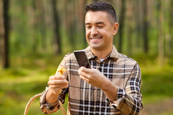 Hombre usando el teléfono inteligente para identificar hongos —  Fotos de Stock