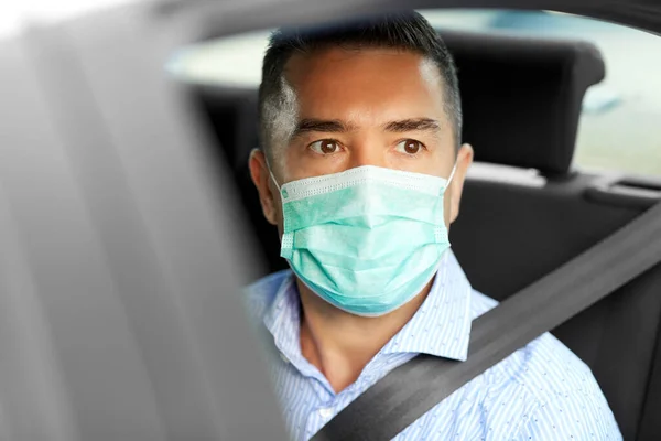 Man or male passenger wearing mask in car — Stock Photo, Image