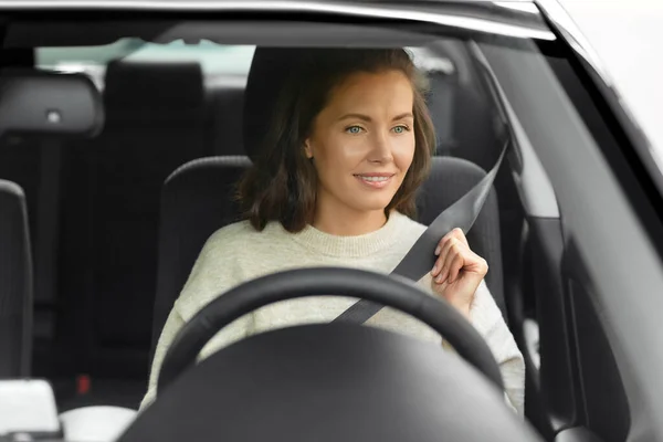Женщина или женщина водитель автомобиля пристегивая ремень безопасности — стоковое фото