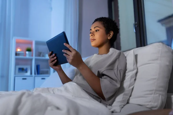 Vrouw met tablet pc in bed thuis 's nachts — Stockfoto