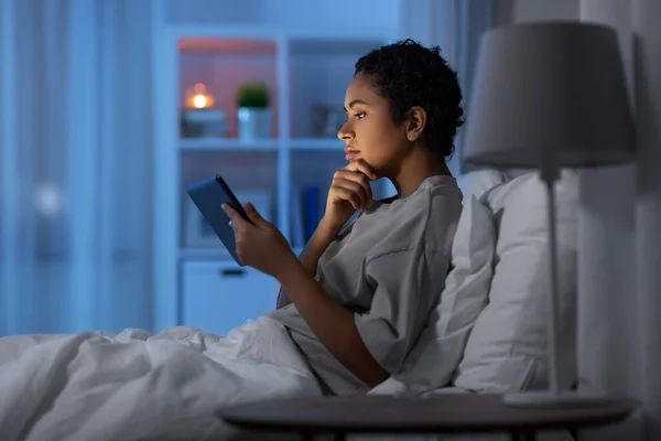 Vrouw met tablet pc in bed thuis 's nachts — Stockfoto