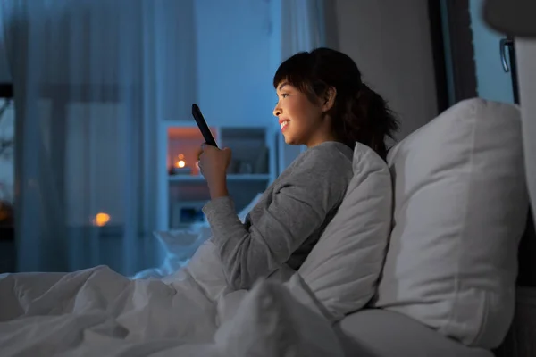 Asiatique femme avec smartphone dans lit la nuit — Photo