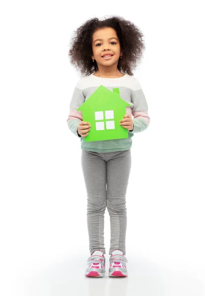 Smiling african girl holding green house icon — Stock Photo, Image