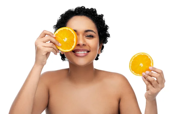 Mujer africana sonriente haciendo máscara de ojos de naranjas — Foto de Stock