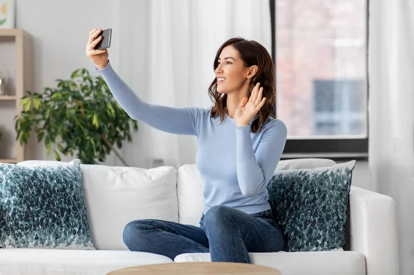 Glückliche Frau mit Smartphone macht Selfie zu Hause — Stockfoto