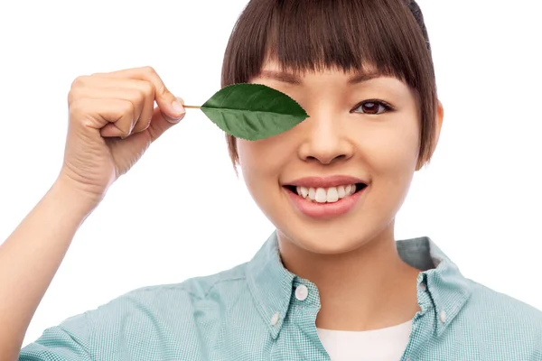 Sorridente asiatico donna holding verde foglia — Foto Stock