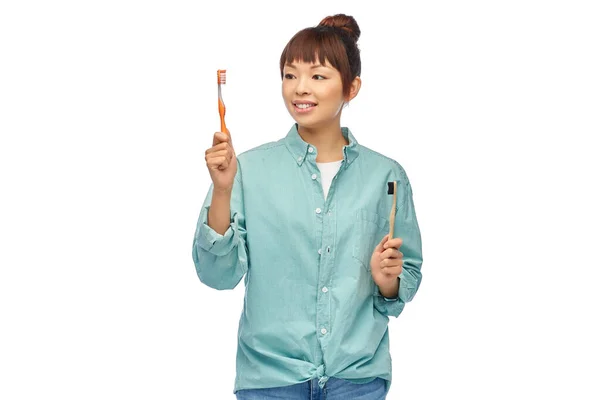 Donna asiatica con spazzolini in legno e plastica — Foto Stock