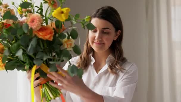 Szczęśliwa kobieta organizując kwiaty w wazonie w domu — Wideo stockowe