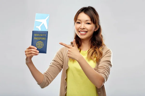 Asiatisk kvinna med flygbiljett och immunitetspass — Stockfoto