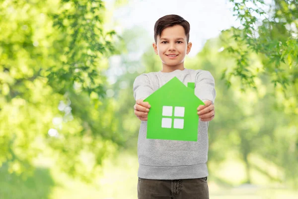 Sonriente chico sosteniendo verde casa icono — Foto de Stock