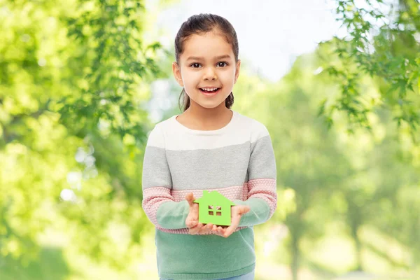 Smiling little girl holding green house icon — Stock Photo, Image
