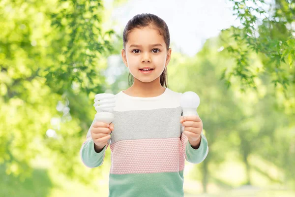 Sorrindo menina comparando lâmpadas diferentes — Fotografia de Stock