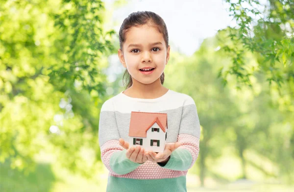 Sorridente menina segurando casa modelo — Fotografia de Stock