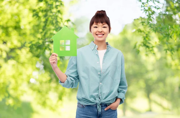 Sonriente asiático mujer holding verde casa — Foto de Stock