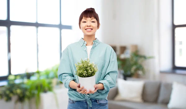 Szczęśliwy uśmiechnięty Azji kobieta gospodarstwa kwiat w puli — Zdjęcie stockowe