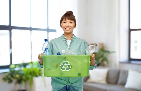 Усміхнена молода азіатська жінка сортує пластикові відходи — стокове фото