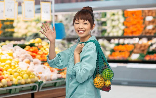 Asiatin mit Lebensmitteln in Mehrwegtasche im Laden — Stockfoto