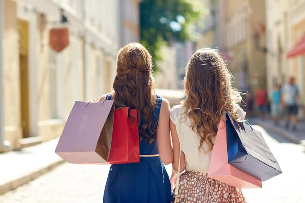 Vrouwen met boodschappentassen wandelen in de stad — Stockfoto