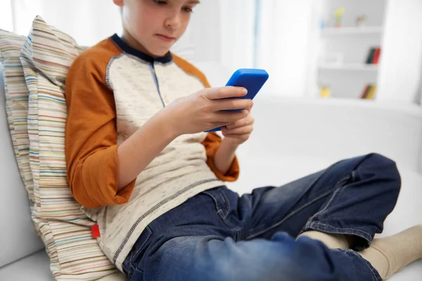 Close up of boy with smartphone at home — Stock Photo, Image